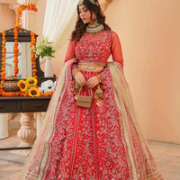 Woman in a red and gold traditional outfit standing in a decorated indoor setting.